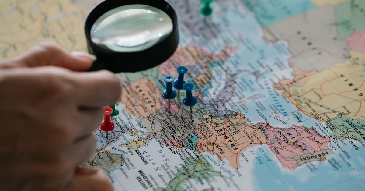 Magnifying glass focuses on pins highlighting travel destinations on a world map.